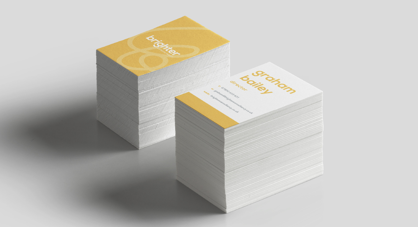 An angled photo of a stack of business cards, showing both the front and back of the design.