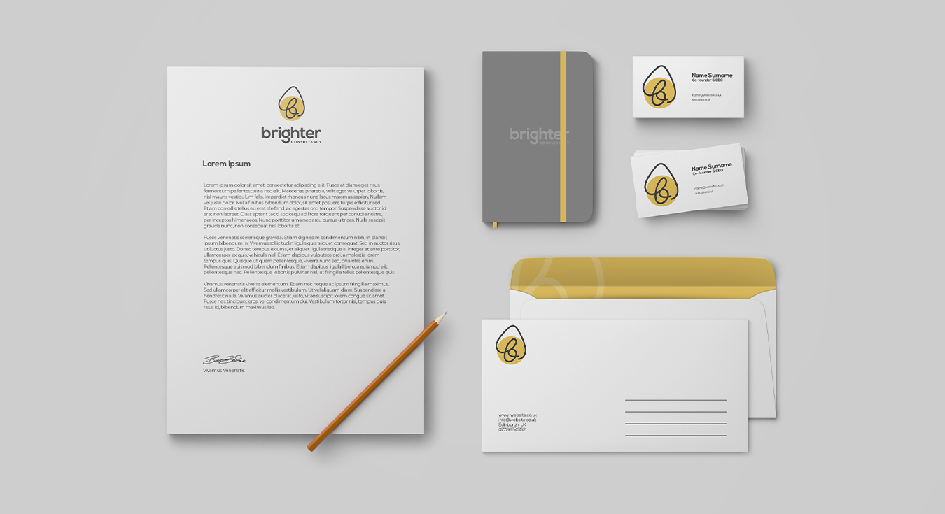 A top-down image of Brighter Consultancy branded stationery, including a letterhead, notebook, business cards and envelopes.