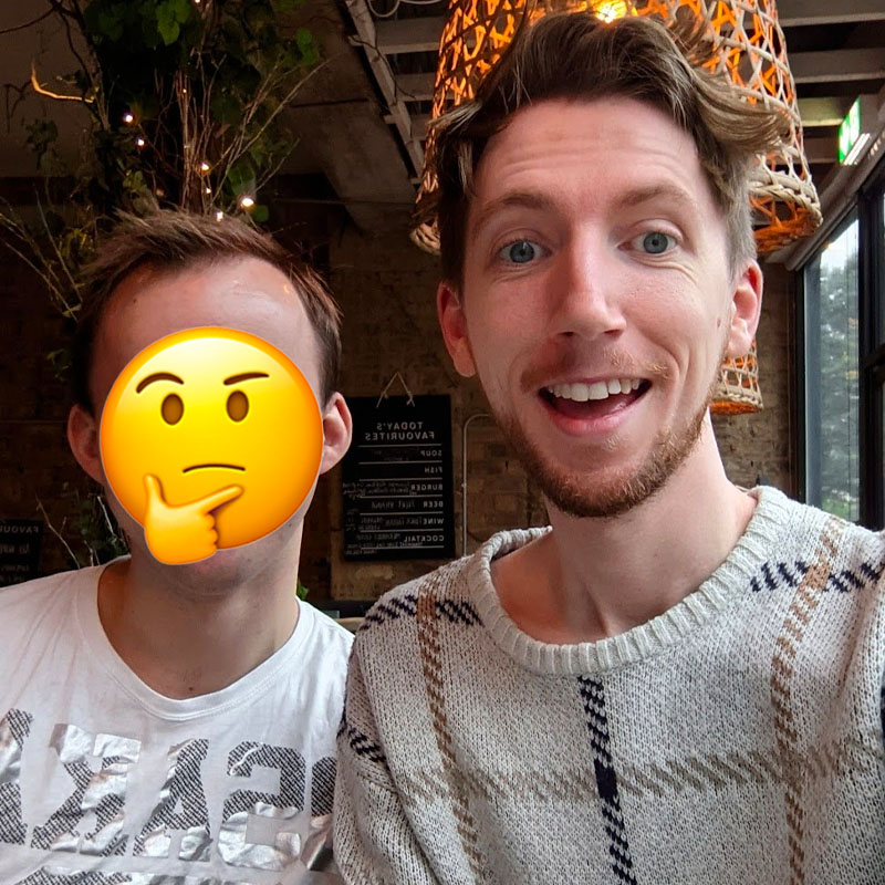 A photo of Chris and a mentorship student in a coffee shop. An emoji covers the face of the student.