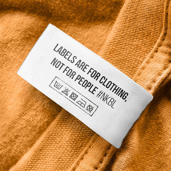A retouched image of the same photo of a T-shirt label, with text added: Labels are for clothing, not for people.