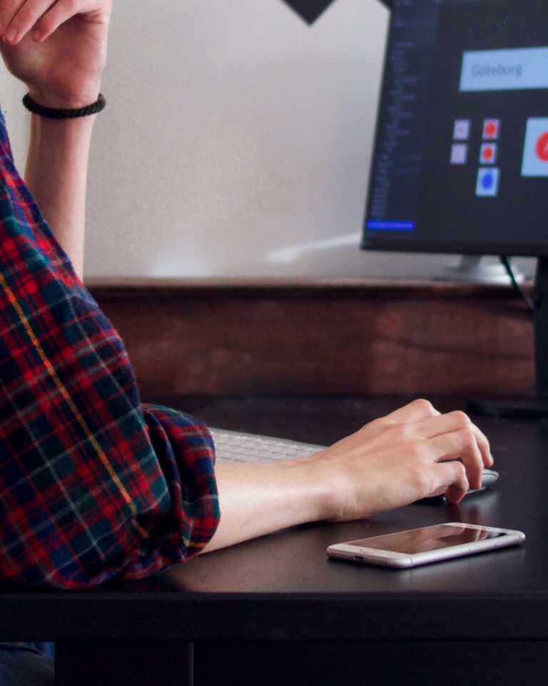 Man in a plaid shirt, designing on a computer.