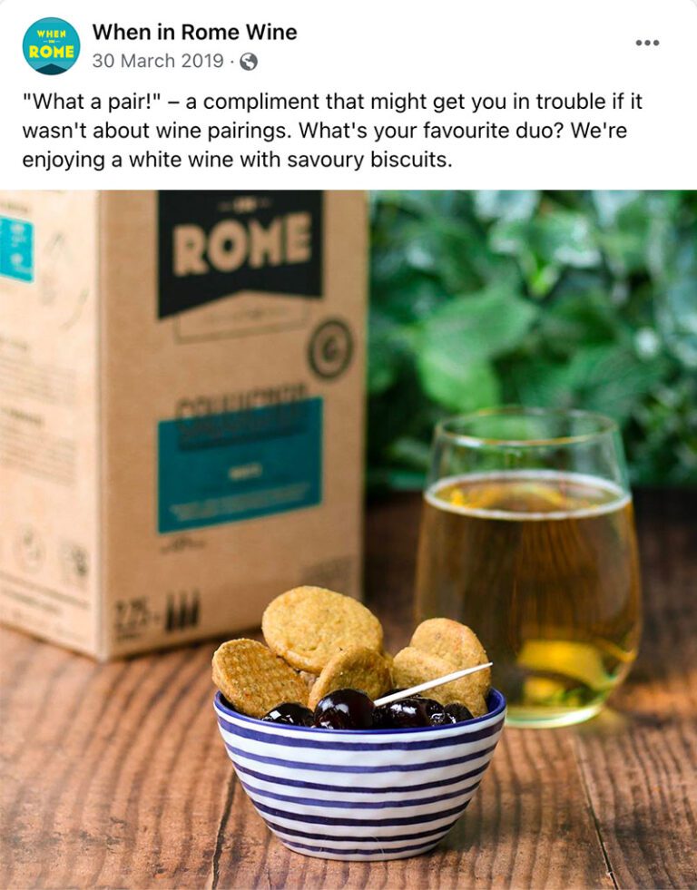 A screenshot of a social media post saying: What a pair! A compliment that might get you in trouble if it wasn't about wine pairings. What's your favourite duo? We're enjoying a white wine with savoury biscuits. Below, there is a photo of When In Rome wine with biscuits.