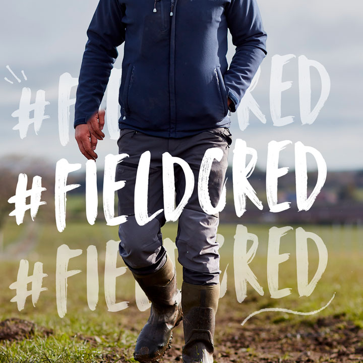 A farmer walking in muddy farmland with hashtag field cred edited around him.